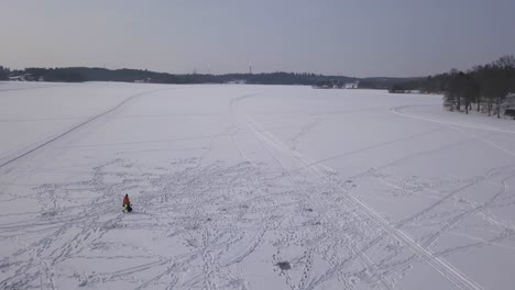 Imágenes-Aéreas-Panorámicas-Que-Revelan-La-Inmensidad-De-Un-Lago-Congelado-Con-Un-Solo-Hombre-Caminando-Mostrando-La-Escala-Del-Lago.