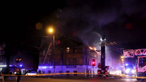 Feuerwehrleute-Richten-Wasserstrahl-Auf-Brennendes-Haus