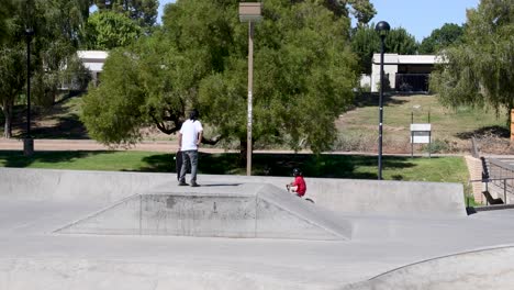 El-Hombre-Mira-Al-Chico-Justo-En-Su-Bicicleta-En-El-Parque-De-Patinaje-En-Cuña,-Scottsdale,-Arizona