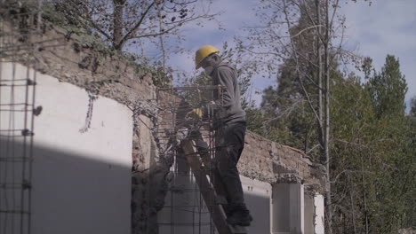 Mann-Mit-Einem-Bohrhammer,-Der-Einen-Teil-Einer-Alten-Mauer-Auf-Einer-Baustelle-Beseitigt,-In-Full-HD-Zeitlupe-Mit-60-Bildern-Pro-Sekunde