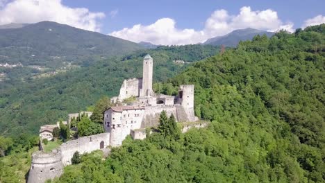 Vista-Aérea-De-Castel-Telvana-En-Borgo-Valsugana,-Trentino,-Italia-Con-Drones-Volando-Hacia-Adelante-En-Un-Día-Muy-Claro