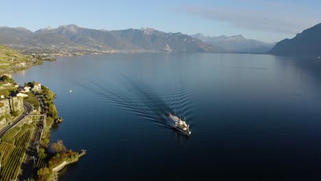 Aerial-orbit-descending-towards-CGN-Belle-Epoque-steam-boat-on-Lake-Léman-revealing-Rivaz-typical-village-in-Lavaux-vineyard---Switzerland-Autumn-colors-and-sunset-light