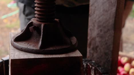 Close-up-of-screw-threads-turning-while-cider-press-block-squeezes-down