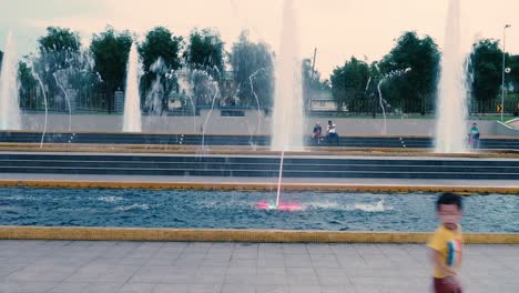 Asiatischer-Junge-Läuft-Abends-Vor-Dem-Brunnen-Des-Laman-Serene-Park-In-Johor-Bahru