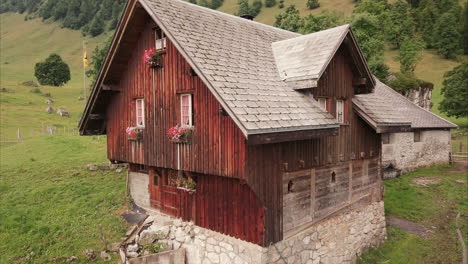 Romantisches-Bauernhaus-Aus-Holz-In-Den-Schweizer-Bergen,-Luftdrohnenflug