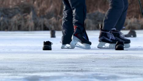 A-close-up-static-shot-of-people-skating-on-ice-with-hockey-sticks