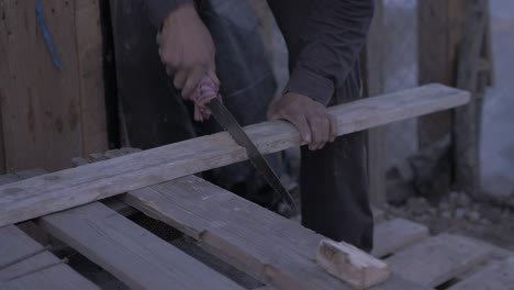 Refugee-cutting-pallet-wood-timber-to-build-a-shelter-Moria-camp-jungle-olive-grove-MID-SHOT