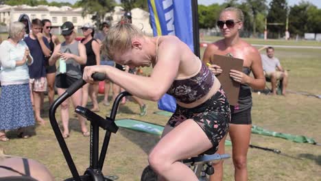 Sportlerin,-Die-Bei-Einem-Cross-Fit-Wettbewerb-Hart-Auf-Einem-Luftfahrrad-Konkurriert