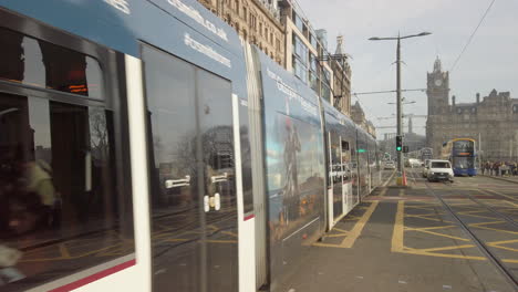 A-tram,-buses-and-general-traffic-in-Princes-Street,-looking-towards-Calton-Hill-on-a-sunny-day,-Edinburgh,-Scotland