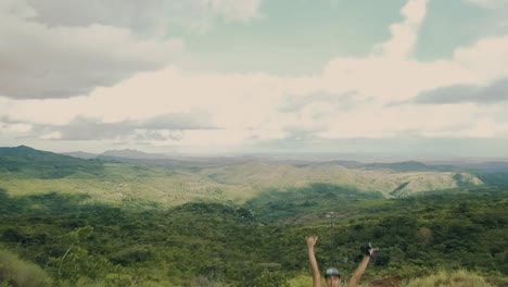 Drone-footage-of-a-young-man-rising-his-hands-after-he-got-to-the-top-of-a-cliff