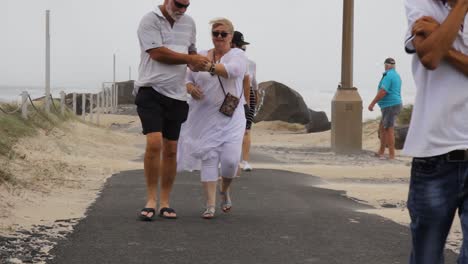 Groups-of-people-coming-to-look-at-damage-to-a-beach-caused-by-a-developing-cyclone