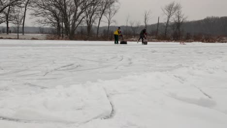 Un-Par-De-Adultos-Limpian-La-Nieve-Con-Palas-Del-Campo-De-Hockey-Del-Estanque