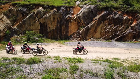 Vista-Lateral-De-Drones-En-Cámara-Lenta-De-Un-Grupo-De-Motociclistas-Despegando-Después-De-Descansar-A-Lo-Largo-Del-Paso-Ma-Pi-Leng,-Vietnam