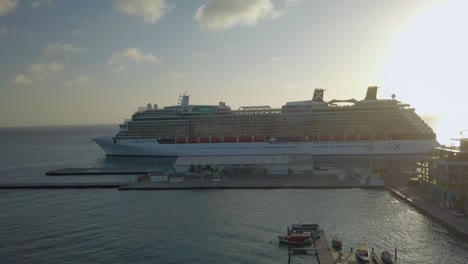 Luftaufnahme-Eines-Großen-Kreuzfahrtschiffes,-Das-An-Einem-Sonnigen-Tag-Das-Dock-Verlässt,-4k