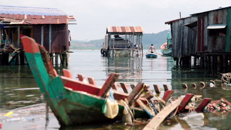 Plastic-derbis-pollution-in-a-floating-floating-with-man-on-the-background-in-Cambodia