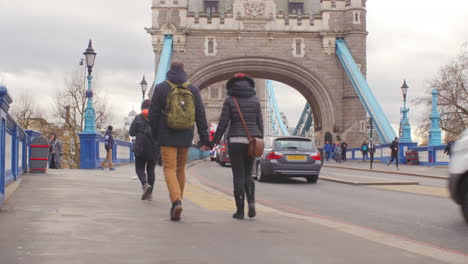 Pareja-De-Adultos-Jóvenes-Tomados-De-La-Mano-Mientras-Cruzan-El-Puente-De-La-Torre-De-Londres