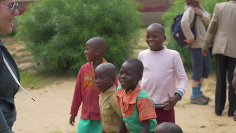 Un-Visitante-Estadounidense-Enseña-A-Los-Escolares-De-Zimbabue-A-Bailar-Al-Aire-Libre-En-Un-Día-Soleado,-Movimiento-Giratorio-De-Cámara-Estable