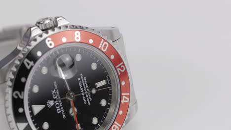 Hermoso-Reloj-Rolex-Gmt-master-Ii-Cocke,-Girando-En-Una-Pantalla-Blanca,-Fotografiado-Con-Una-Lente-Macro