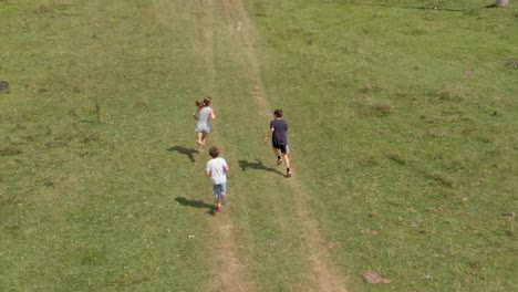 Los-Niños-Corren-Y-Juegan-En-El-Campo-Verde---Cámara-Lenta-Aérea