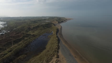 Aerial-view-of-a-beach-on-the-coastline-on-the-English-Lake-District-on-a-still-sunny-day