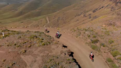 Vista-Aérea-Siguiendo-A-Ciclistas-De-Montaña-Bajando-Un-Paso-De-Montaña-60fps