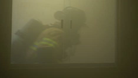 Los-Bomberos-Corren-Por-Una-Ventana-En-Un-Edificio-Lleno-De-Humo-Mientras-Responden-A-Una-Emergencia-Y-Buscan-Personas-Para-Rescatar-De-Una-Oficina-En-Llamas