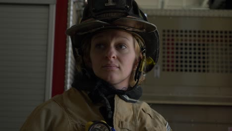 Female-firefighter-puts-on-protective-firefighting-helmet-and-gear-as-she-prepares-to-respond-to-an-emergency