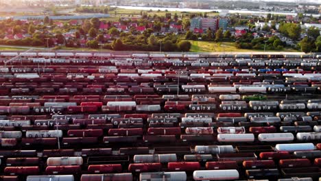 Toma-Aérea-Que-Muestra-Un-Gran-Depósito-De-Trenes-Con-Muchos-Trenes-De-Carga-Coloridos