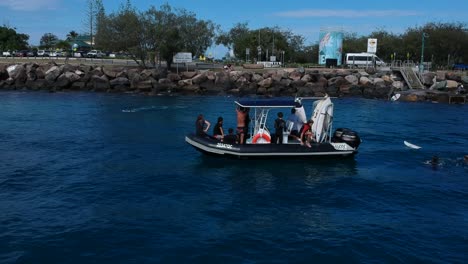 A-group-of-surfers-getting-off-a-water-taxi-boat-and-swimming-to-shore