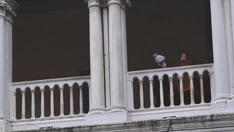 Two-tourists-on-the-phone-framed-by-beautiful-Venetian-architecture