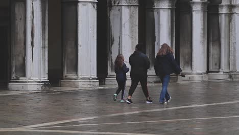 Drei-Menschen-Gehen-An-Einem-Regnerischen-Tag-Auf-Dem-Markusplatz-In-Venedig-Spazieren