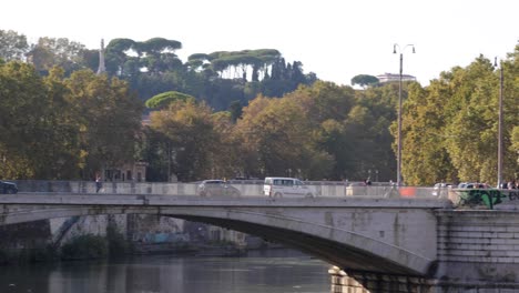 Toma-Panorámica-De-Un-Hermoso-Puente-Antiguo-En-La-Ciudad-De-Roma-Sobre-El-Río-Tíber,-Italia