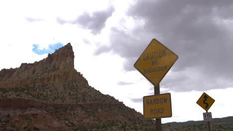 A-caution-sign-with-a-sandstone-tower-behind-it-at-capitol-reef-national-park