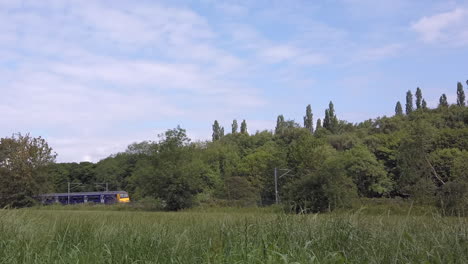 Static-Shot-of-a-Northern-Train-Passing-By-the-Rural-Outskirts-of-Leeds-in-Slow-Motion-with-Narrow-Crop