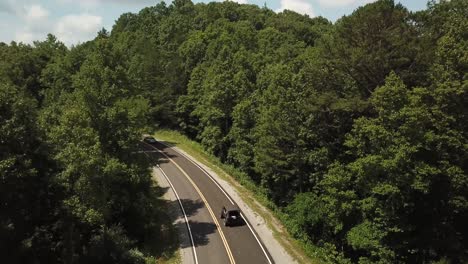 Cars-driving-down-a-mountain-road-at-midday