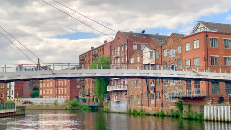 Fußgänger-überqueren-Den-Fluss-Aire-Auf-Der-Centenary-Bridge-In-Leeds,-Großbritannien-An-Einem-Sommerabend-Mit-Wolkenverhangenem-Blauen-Himmel