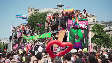 Gente-De-Fiesta-En-La-Parte-Superior-Y-En-El-Interior-De-Un-Vehículo-Decorado-Con-Colores-Que-Pasa-A-Través-De-La-Gente-En-La-Marcha-Del-Orgullo-Gay-En-París,-Francia