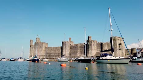 Caernarfon-Castle-Geschossen-Vom-Fluss-Seiont-Und-Zeigt-Die-Schlossfassade-Und-Den-Umliegenden-Tourismus-Und-Die-Boote