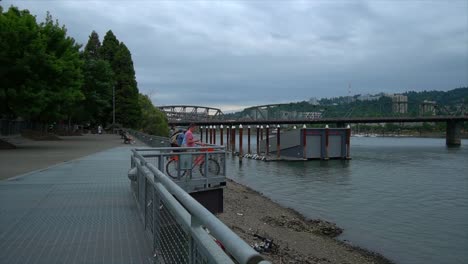 Ciclistas-Disfrutando-De-La-Vista-Del-Centro-De-Portland-Y-El-Río-Willamette-Desde-La-Explanada-Del-Lado-Este.