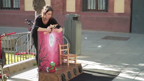 Mujer-Joven-Montando-Un-Espectáculo-De-Marionetas-En-Las-Calles