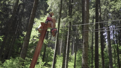 Niña-Con-El-Pelo-Rojo-Montando-Una-Bicicleta-De-Madera-En-El-Parque-De-Aventuras-En-Los-Alpes-Italianos-A-Cámara-Lenta-100fps