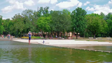 Värosligeti-See-Stadtpark,-Die-Andere-Seite-Des-Parks,-Menschen-überqueren-Den-Mini-Dampf,-Schnelle-Vorwärtsaufnahme,-Fortsetzung