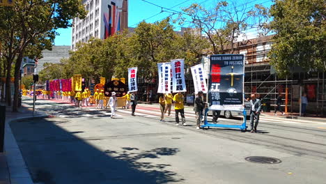 Falun-Dafa,-also-known-as-Falun-Gong,-practitioners-during-march-band-through-streets-of-downtown-in-San-Francisco-protesting-against-religious-persecution-from-chinese-communist-party-of-Jiang-Zemin