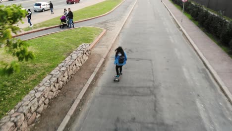 Weiße-Frau,-Die-Auf-Longboard-Die-Straße-Hinunter-In-Montevideo-Uruguay-Skatet