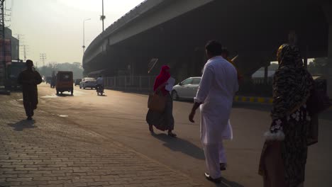 Fast-forward-shot-of-the-Traffic-on-the-road-under-the-fly-over,-passing-motor-bikes-and-cars,-Buses,-rickshaw`s,-Billboards,-buildings,-electric-polls-and-street-lights