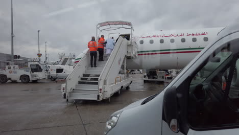 Aeropuerto-De-París-Orly,-Visto-Desde-Un-Transbordador-De-Pasajeros-Frente-A-Un-Avión-De-Royal-Air-Maroc,-Empleados-Que-Ayudan-A-Una-Persona-Mayor-A-Abordar-El-Avión