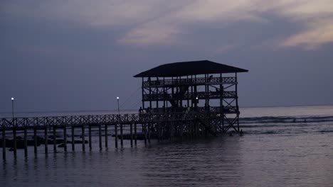 Scenic-view-of-the-Cloud9-boardwalk-with-the-sun-low-and-out-of-frame,-silhouetted-against-a-cloudy-sky,-filmed-in-UHD-4K