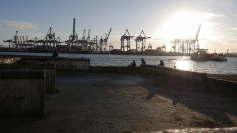 Timelapse-of-the-Hamburg-harbor-at-sundown-with-cranes-in-the-background