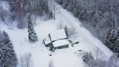 Orbiting-around-a-snow-covered-camp-deep-in-the-woods-SLOW-MOTION-AERIAL