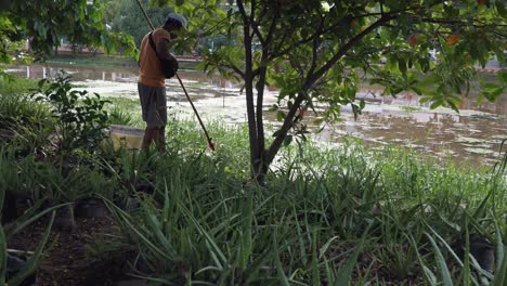 Schwenk-Vorbei-An-Einem-Asiatischen-Mann,-Der-Den-Fluss-Vor-Dem-Wasserfest-Reinigt